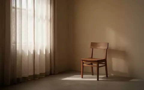 Ein minimalistisch eingerichteter, ruhiger Raum mit sanftem Tageslicht, das durch einen Vorhang in eine leere Ecke fällt. - Foto: über boerse-global.de