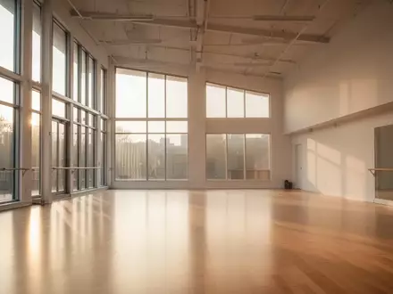 Ein lichtdurchfluteter, leerer Tanzsaal mit hellem Holzboden und hohen Fenstern. - Foto: über boerse-global.de