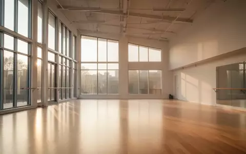 Ein lichtdurchfluteter, leerer Tanzsaal mit hellem Holzboden und hohen Fenstern. - Foto: über boerse-global.de