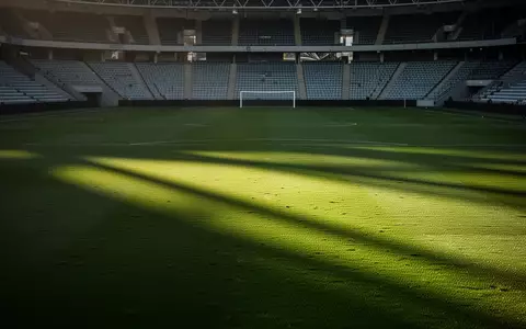 Ein leerer, gepflegter Fußballplatz in einem Stadion bei natürlichem Tageslicht. - Foto: über boerse-global.de