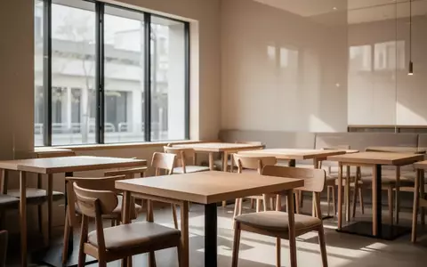Ein minimalistischer, leerer Gastraum eines Restaurants mit hellen Holzmöbeln und natürlichem Tageslichteinfall. - Foto: über boerse-global.de
