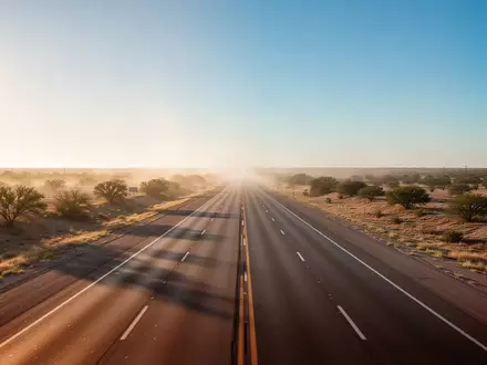 Eine leere Autobahnstrecke der Interstate 45 in Texas bei Sonnenuntergang in einer weiten, flachen Landschaft. - Foto: über boerse-global.de