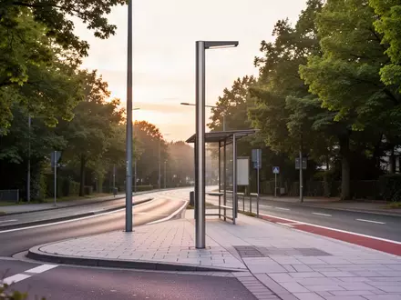 Eine leere, modern gestaltete Bushaltestelle an einer ruhigen Straße im Rhein-Main-Gebiet im Morgenlicht. - Foto: über boerse-global.de