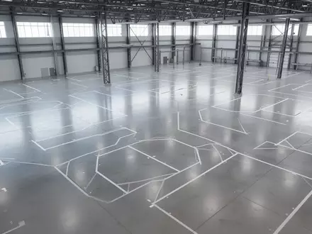Eine weitläufige, moderne Industriehalle mit poliertem Betonboden und modular angeordneten, leeren Montagebereichen. - Foto: über boerse-global.de