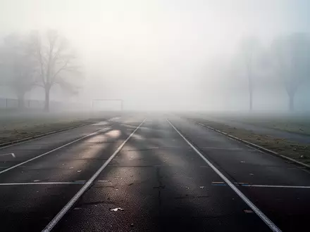 Eine leere, neblige Laufbahn in den frühen Morgenstunden, die sich in die Ferne erstreckt. - Foto: über boerse-global.de