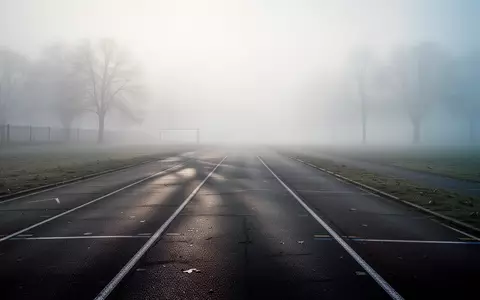 Eine leere, neblige Laufbahn in den frĂŒhen Morgenstunden, die sich in die Ferne erstreckt. - Foto: ĂŒber boerse-global.de