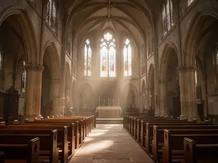 Innenansicht einer leeren, lichtdurchfluteten Kathedrale mit hohen Steingewölben und Holzbänken. - Foto: über boerse-global.de
