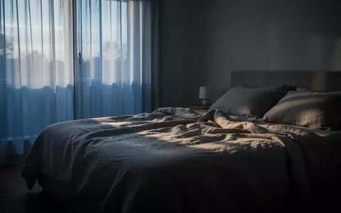 Ein ruhig gestaltetes Schlafzimmer im sanften Licht der Morgendämmerung mit einem ungemachten Bett. - Foto: über boerse-global.de