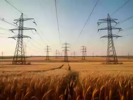 Hochspannungsmasten ragen über einem weiten Feld auf und symbolisieren die Stromnetzinfrastruktur. - Foto: über boerse-global.de