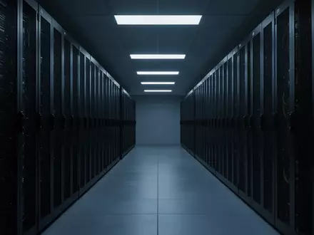 Leere, dunkle Serverraum-Gänge mit schweigenden Rechenzentrums-Racks in einer sterilen, technologischen Umgebung. - Foto: über boerse-global.de