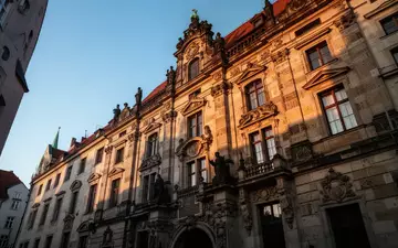 Historische Sandsteinfassade eines Gebäudes in der Münchner Altstadt im warmen Licht der Abendsonne. - Foto: über boerse-global.de