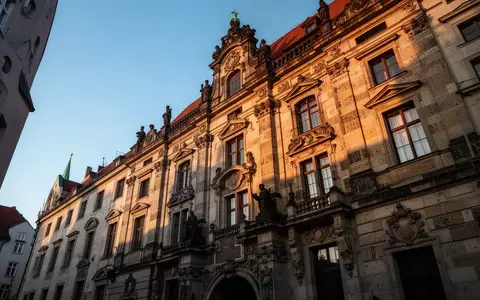 Historische Sandsteinfassade eines Gebäudes in der Münchner Altstadt im warmen Licht der Abendsonne. - Foto: über boerse-global.de