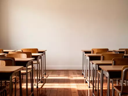Ein leerer, ruhiger Klassenraum mit Holztischen und Stühlen in einer hellen, konzentrierten Lernumgebung. - Foto: über boerse-global.de