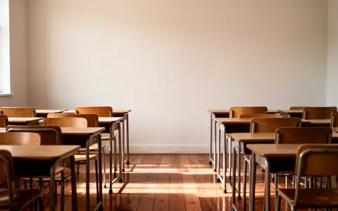Ein leerer, ruhiger Klassenraum mit Holztischen und Stühlen in einer hellen, konzentrierten Lernumgebung. - Foto: über boerse-global.de
