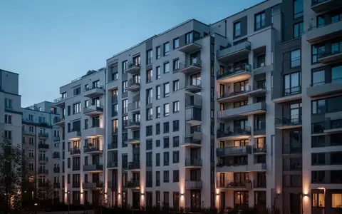 Ein modernes Wohngebäude in einer deutschen Stadt bei Dämmerung, das die städtische Architektur und Wohnsituation verdeutlicht. - Foto: über boerse-global.de