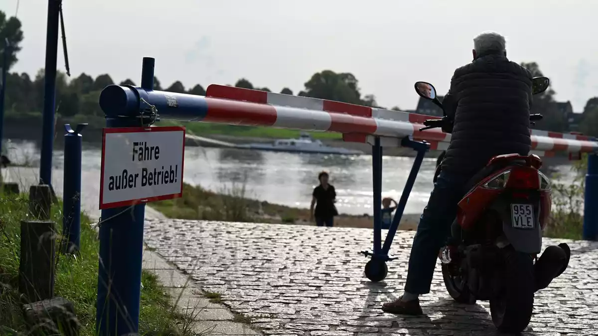 Das Warten auf die Fähre ist vergeblich: Ein Motorroller-Fahrer blickt einige Minuten auf den Rhein, dann kehrt er um und fährt davon. (Archivbild) - Bild: Wolf von Dewitz/dpa