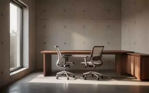 Ein minimalistisch eingerichteter, lichtdurchfluteter Arbeitsraum mit einem Holztisch vor einer neutralen Betonwand. - Foto: über boerse-global.de