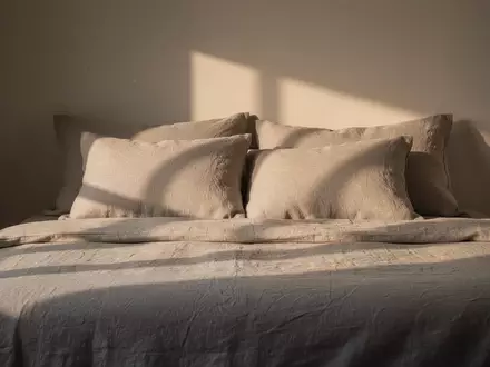 Ein minimalistisch gestaltetes Schlafzimmer mit hochwertiger Bettwäsche bei sanftem Morgenlicht zur Veranschaulichung von Schlafkomfort. - Foto: über boerse-global.de