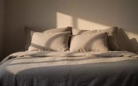 Ein minimalistisch gestaltetes Schlafzimmer mit hochwertiger Bettwäsche bei sanftem Morgenlicht zur Veranschaulichung von Schlafkomfort. - Foto: über boerse-global.de