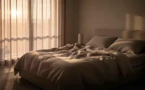 Ein ruhiges Schlafzimmer im sanften Licht der Morgendämmerung mit ungemachtem Bett und neutraler Bettwäsche. - Foto: über boerse-global.de