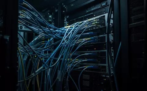 Dunkle, technologische Umgebung mit miteinander verbundenen Kabeln und Serverkomponenten in einem gesicherten Rechenzentrum. - Foto: über boerse-global.de