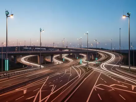 Eine moderne, weitläufige Autobahninfrastruktur mit intelligenter Beleuchtung in der Abenddämmerung ohne Fahrzeuge. - Foto: über boerse-global.de