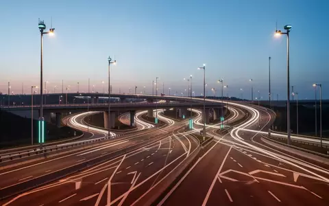 Eine moderne, weitläufige Autobahninfrastruktur mit intelligenter Beleuchtung in der Abenddämmerung ohne Fahrzeuge. - Foto: über boerse-global.de