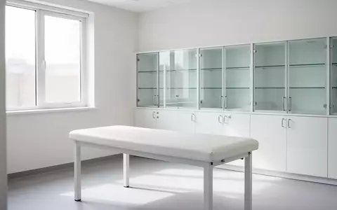 Ein minimalistisch eingerichteter, heller Behandlungsraum in einer Kinderarztpraxis mit einer Untersuchungsliege. - Foto: über boerse-global.de