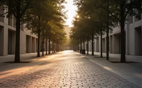 Ein sauberer, gepflasterter Gehweg in einer städtischen Umgebung mit Bäumen und weichem Licht. - Foto: über boerse-global.de