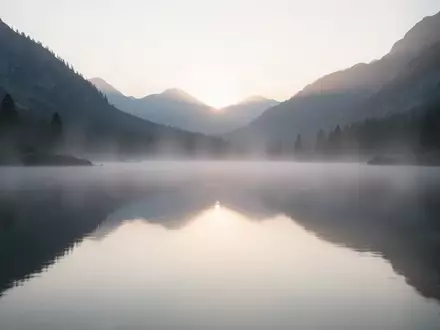 Ein ruhiger Bergsee bei Tagesanbruch, der eine friedliche und entspannte Atmosphäre vermittelt. - Foto: über boerse-global.de