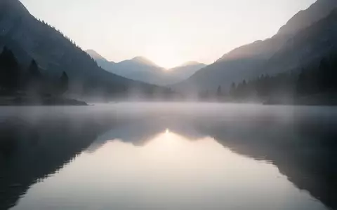 Ein ruhiger Bergsee bei Tagesanbruch, der eine friedliche und entspannte Atmosphäre vermittelt. - Foto: über boerse-global.de