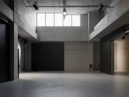 Ein minimalistischer, modern gestalteter Industrieraum mit klaren architektonischen Linien und matt-dunklen Oberflächen. - Foto: über boerse-global.de