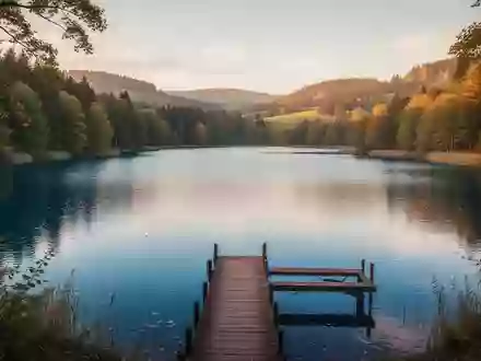 Ein ruhiger deutscher Binnensee in herbstlicher Landschaft mit einem hölzernen Steg und reflektierendem Wasser. - Foto: über boerse-global.de