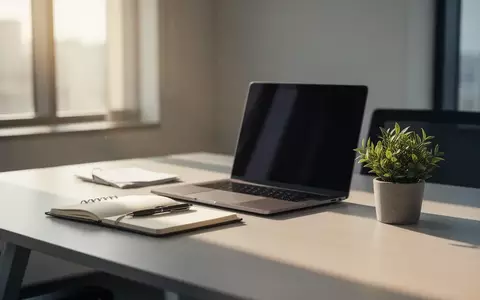 Ein aufgeräumter, professioneller Schreibtisch mit Laptop und Notizbuch in modernem Büroambiente. - Foto: über boerse-global.de