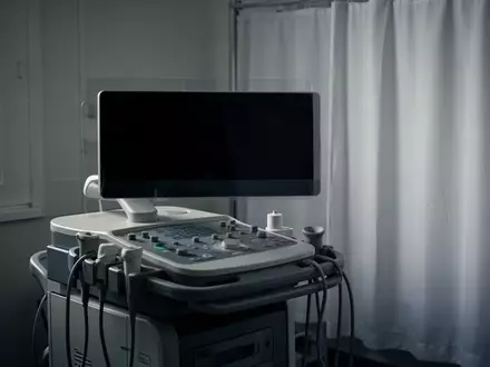 Ein steriler Behandlungsraum mit einem ausgeschalteten EKG-Gerät in einer ruhigen, klinischen Umgebung. - Foto: über boerse-global.de