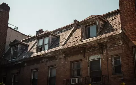 Fassade eines älteren Wohnhauses mit ungedämmten Dachfenstern bei strahlendem Sonnenschein. - Foto: über boerse-global.de