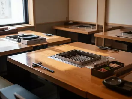 Modernes, leeres japanisches Restaurant mit Holztischen und Grillvorrichtungen in einer gehobenen, hellen Umgebung. - Foto: über boerse-global.de
