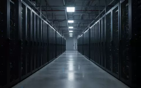 Eine weitläufige, dunkle Serverhalle mit Reihen von unbeleuchteten Serverracks in einer kühlen, industriellen Umgebung. - Foto: über boerse-global.de
