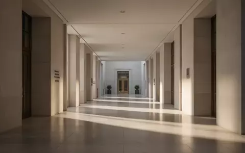 Ein leerer, minimalistischer Flur in einem öffentlichen Gebäude mit klaren architektonischen Linien und natürlichem Lichteinfall. - Foto: über boerse-global.de