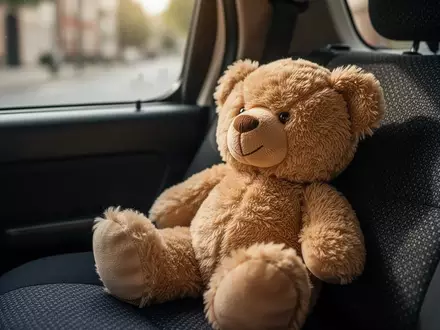 Ein weicher Stoffteddybär auf einem dunklen Autositz in einem Polizeifahrzeug. - Foto: über boerse-global.de