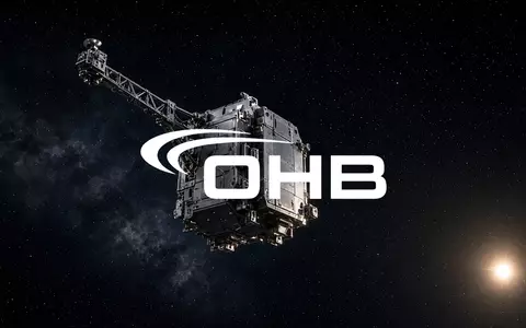 Ein hochmodernes Satellitenbauteil schwebt im Weltraum vor einem dunklen Hintergrund mit dezentem Sternenlicht. - Foto: über boerse-global.de