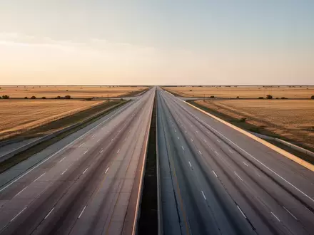 Eine weitläufige, leere Autobahn in der texanischen Landschaft bei Dämmerung. - Foto: über boerse-global.de