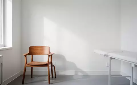 Ein leerer, minimalistischer Behandlungsraum in einer Arztpraxis mit einem Stuhl und hellem Tageslicht. - Foto: über boerse-global.de