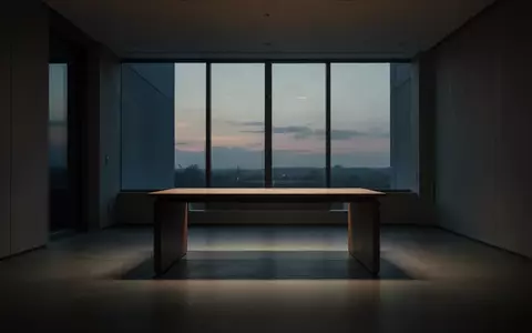Ein minimalistischer, leerer Arbeitsbereich in einem modernen Raum bei Dämmerung, der eine Atmosphäre von Distanz und Stille vermittelt. - Foto: über boerse-global.de