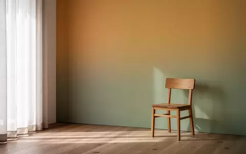 Ein minimalistisch gestalteter Innenraum mit sanftem Lichteinfall und einer Wand in harmonischen, beruhigenden Farbtönen. - Foto: über boerse-global.de