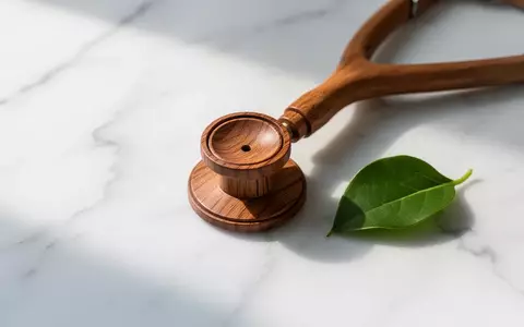 Ein Stethoskop liegt neben einem grünen Blatt auf einer weißen Oberfläche als Symbol für Gesundheitswissen. - Foto: über boerse-global.de