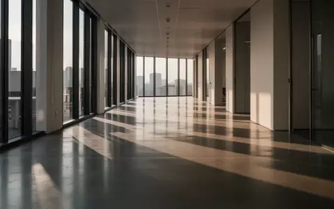 Ein leerer, minimalistischer Büroflur mit langen Schatten auf dem Boden als Symbol für Bewegungsmangel im Alltag. - Foto: über boerse-global.de