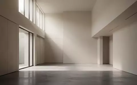 Ein minimalistischer, moderner Innenraum mit klaren Linien und diffusem Tageslicht, das durch hohe Fenster fällt. - Foto: über boerse-global.de
