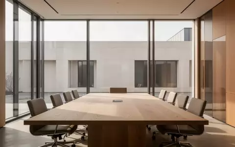 Ein minimalistisch gestalteter, heller Konferenzraum in einem modernen Bürogebäude mit Blick auf eine schlichte Fassade. - Foto: über boerse-global.de