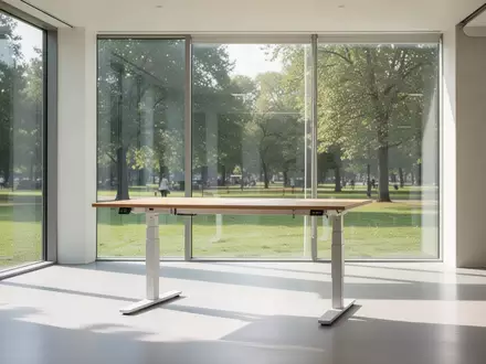 Ein lichtdurchfluteter, minimalistischer Arbeitsbereich mit einem höhenverstellbaren Holztisch und Blick ins Grüne. - Foto: über boerse-global.de